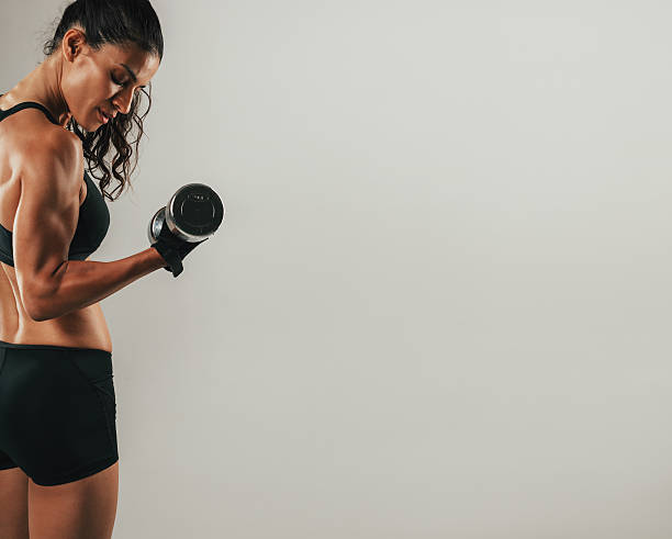 istock Fit young woman working out with a dumbbell 612849572