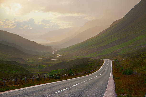 Evening sunlight falls upon the road running down to Loch Maree in Wester Ross, in the Northwest Highlands of Scotland
