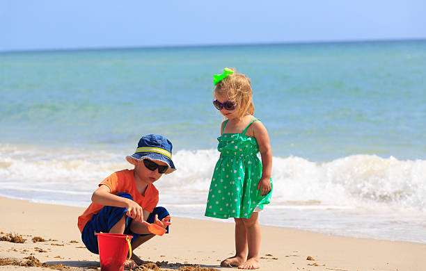 istock kids play with sand on summer beach 612849830