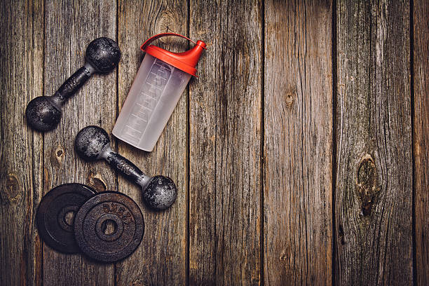istock Fitness workout background. Dumbbells on wooden floor 612850540