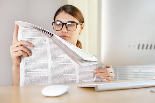 istock Young woman reading newspaper 612850752