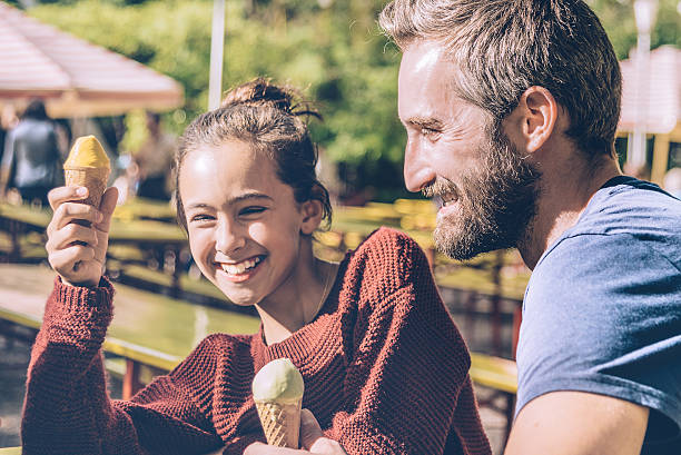 행복한 아버지와 그의 딸이 야외에서 아이스크림을 먹는 - ice cream people food recreational pursuit 뉴스 사진 이미지