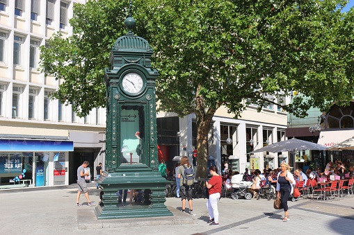 Hannover, Germany - July 19, 2016: Historic Kroepcke Clock made out of Iron in the pedestrian zone of Hannover and passersby. The clock is a traditional meeting Point and a landmark of the City, situated at Kroepcke Square. Germany, Europe.
