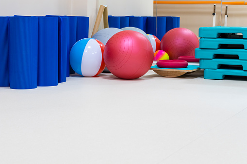 interior of rehabilitation gym, with equiment: balls, mats, steps, mirror