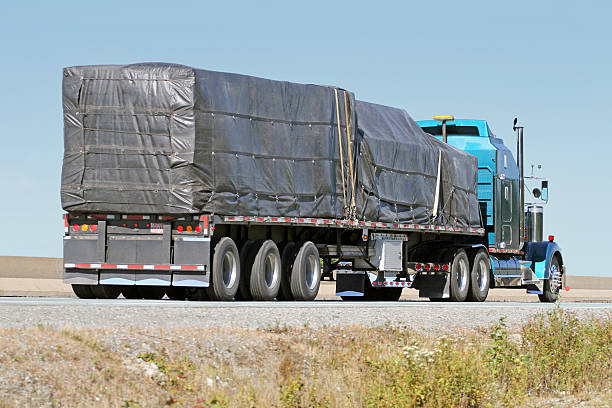 istock Semi Flatbed Truck Hauling A Covered Load On Interstate Highway 612855156