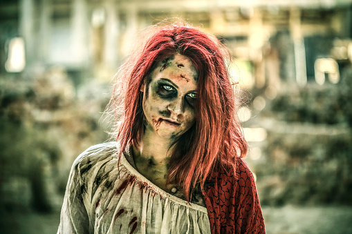 Young woman dressed in zombie costume (halloween concept)