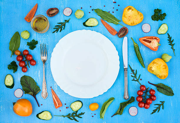 istock Colorfull fresh salad ingredients around empty white plate with silverware 612857018