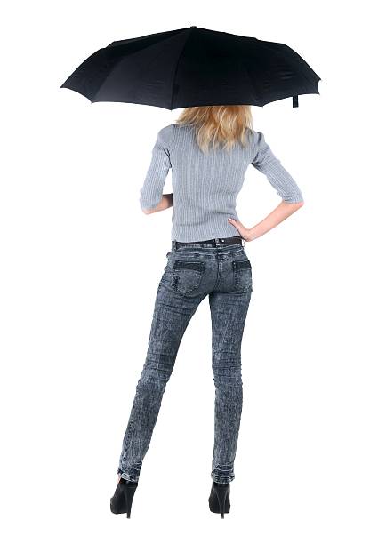istock Blond young woman under an umbrella. Isolated over white. 612858962