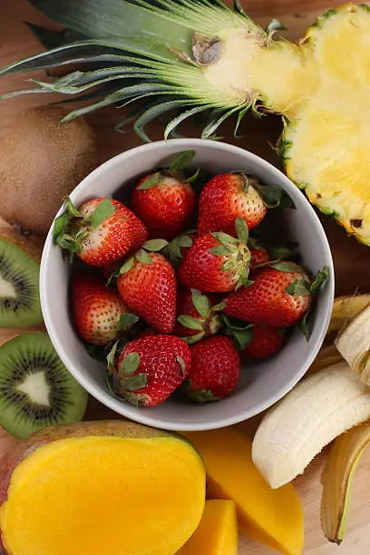 Strawberries rounded by other fruits. 