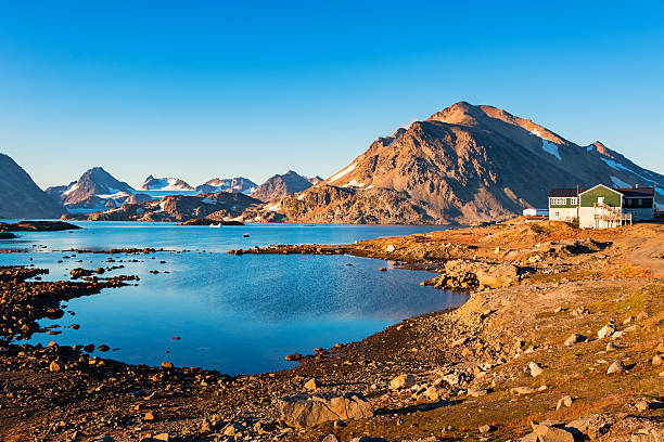 Landscape photo with mountains and barren land during summer at Kulusuk Island, eastern Greenland, on a clear blue sky day.