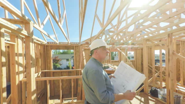 Construction Worker on Site with Building Plans