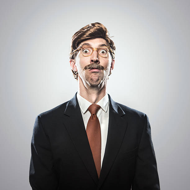 Shocked CEO in Business Suit A corporate manager type business man in full suit, big combover hairstyle and mustache looks at the camera with a surprised expression, or look of fear.  Intentional cliche look for humor.  Square portrait. comb over stock pictures, royalty-free photos & images