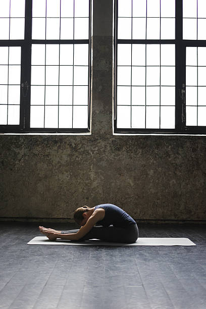 istock Young woman practicing yoga in an urban loft 613012476