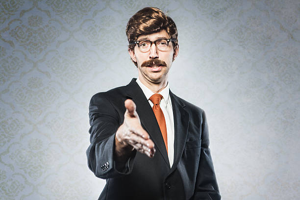 Business Deal CEO A stereotypical corporate manager type business man in full suit, big combover hairstyle and mustache looks at the camera with arm extended for a handshake.  Intentional cliche look for humor.  Horizontal image with copy space. comb over stock pictures, royalty-free photos & images