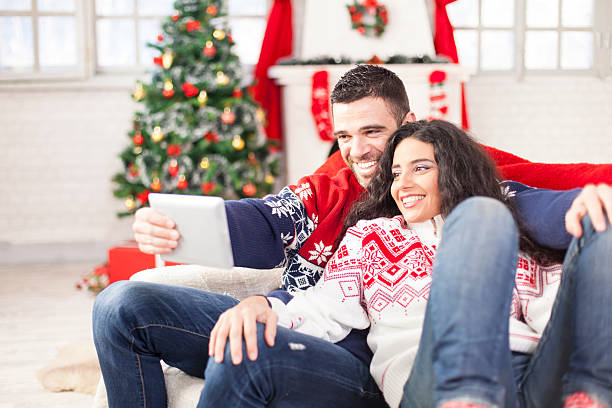 istock Couple sitting on couch and making selfie with digital tablet 613012774