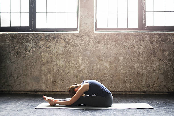 istock Young woman practicing yoga in an urban loft 613012788