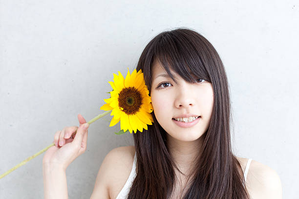 istock Japanese woman holding a sunflower 613013748