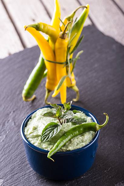 istock Blue bowl with wasabi dip and several chili peppers 613015400