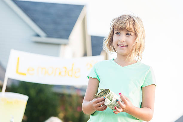 istock Cheerful girl sells lemonade on a summer day 613017766