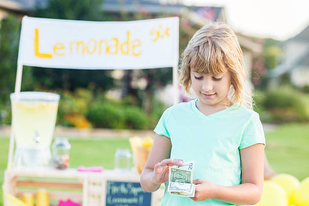 istock Girl counts money made from lemonade sales 613017776
