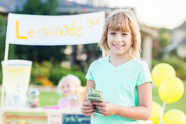 bella ragazza caucasica che vende limonata - child balloon selling sign foto e immagini stock