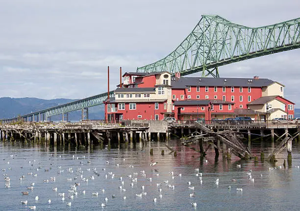 The wooden house standing next to the long bridge over Columbia River (Astoria, Oregon).