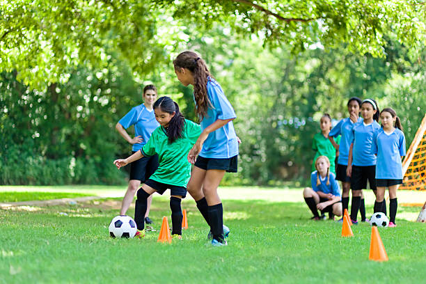 istock Girls soccer team go through practice drills 613020100