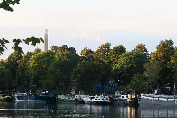 istock industrual chimneys smoking next to canal barges at sunset 613021044