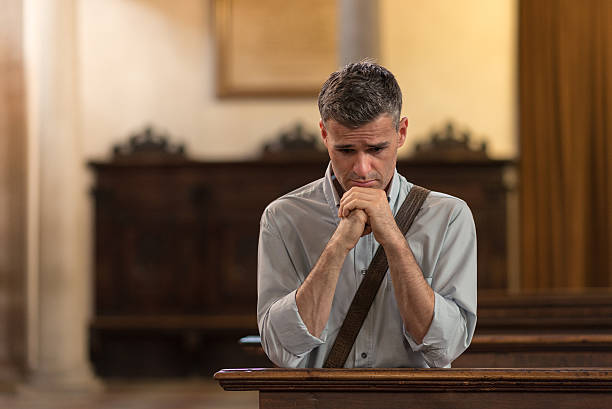istock Man praying in the Church 613021996
