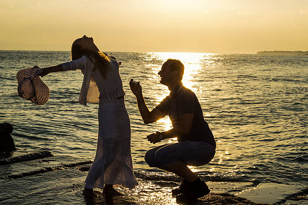 istock Man asking for marry his woman, holding ring at sunrise. 613023260
