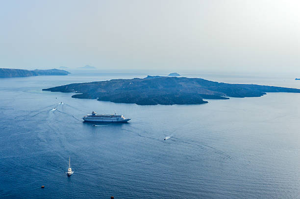 Santorini island, Greece - April, 23, 2023: Cruise ship near the coast. Blue sea and the blue sky. Summer seascape. Travel and vacation concept
