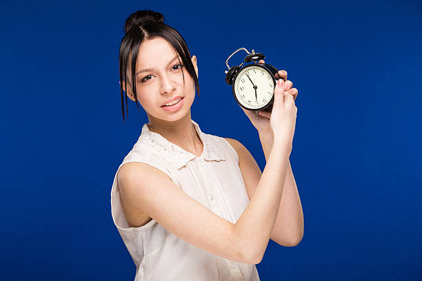 istock girl with an alarm clock 613023970