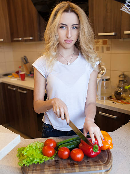 istock blond woman cooking on kitchen. 613024688