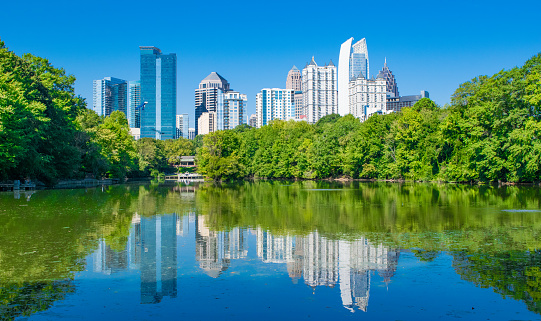The skycrapers of Atlanta, Georgia reflected on a lake in Piedmont Park.