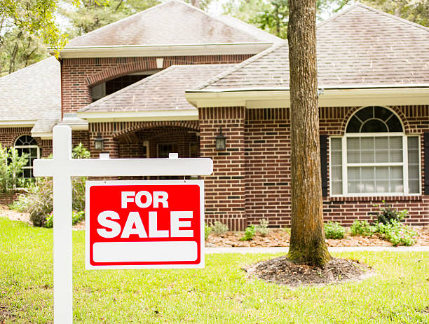 House for sale sign in front yard.