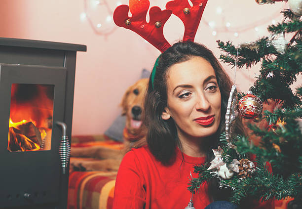 istock Young beautiful woman with dog in a Christmas setting 613030964
