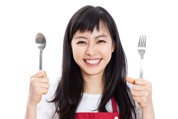 istock Japanese woman holding a spoon and fork 613037910