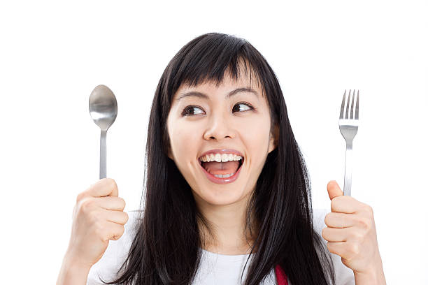 istock Japanese woman holding a spoon and fork 613037916