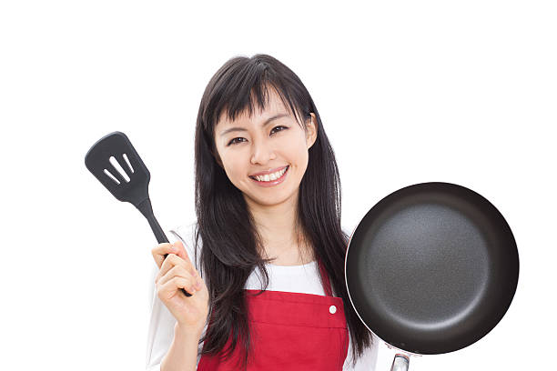 istock Japanese woman holding a pan and a spatula 613038080