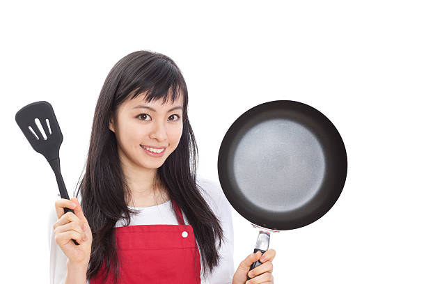 istock Japanese woman holding a pan and a spatula 613038092