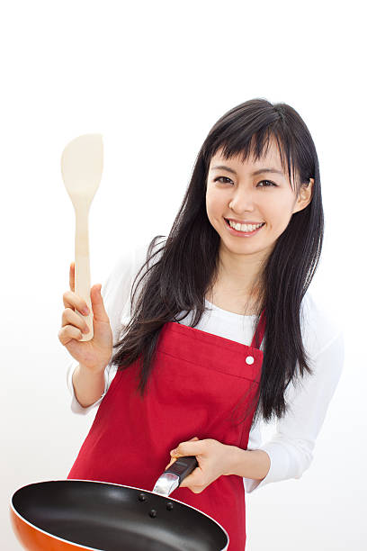 istock Japanese woman holding a pan and a spatula 613038136