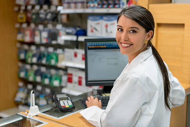 woman working at a pharmacy - retail occupation cash register retail selling imagens e fotografias de stock