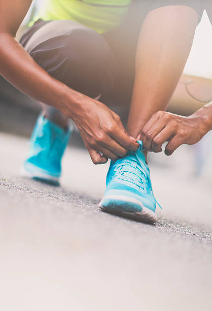 istock Female jogger tying her shoe 613040870