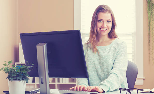 istock Happy young woman on her computer in her home office 613041936