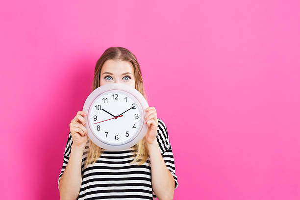 Young woman holding a clock