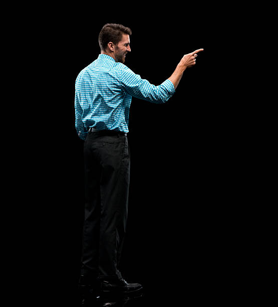 istock Smiling businessman pointing away 613042980
