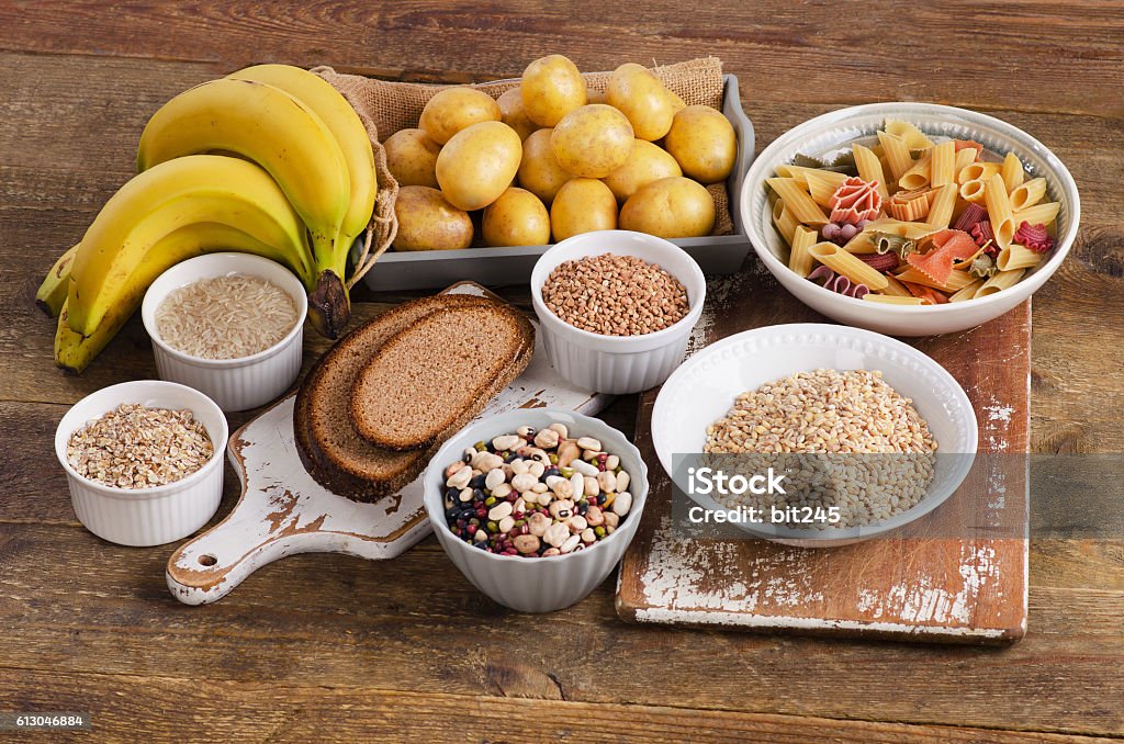 Alimentos ricos en carbohidratos sobre fondo de madera. - Foto de stock de Carbohidrato libre de derechos