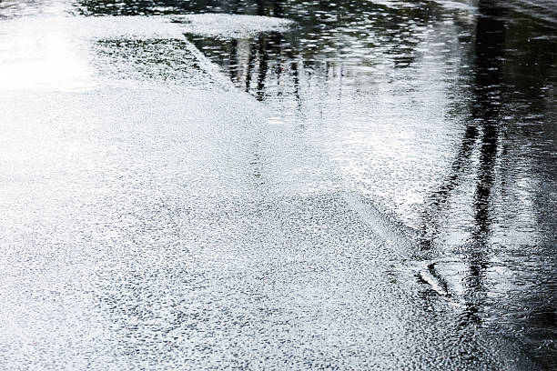 istock water puddles with raindrops falling on them on wet asphalt 613048570