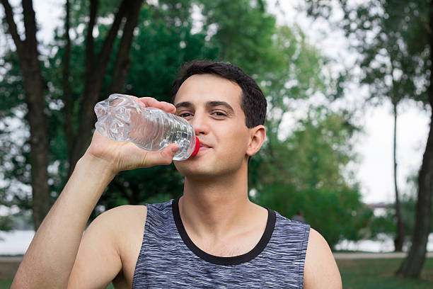 istock Young fitness man drinks water during workout outdoor 613049904