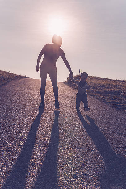 istock Baby walking with help of its parents - first steps 613051962
